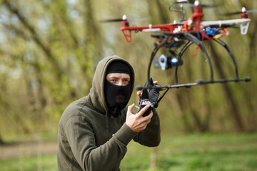 Man in mask operating a drone with remote control.
