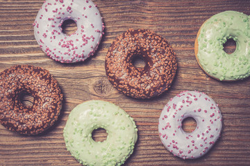 Colorful donuts on wooden table