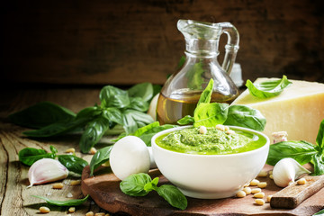 Italian pesto sauce in a white porcelain bowl, ingredients for c