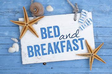 Bed and breakfast mit maritimer Dekoration auf blauem Holzhintergrund 