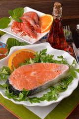 salmon dishes and raw shrimp surrounded with parsley and orange