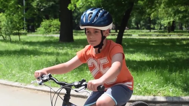 Young boy rides bicycle in park