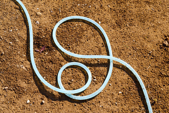 garden hose, dry soil background