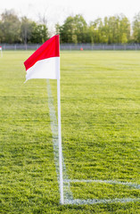 Eine rotweiße Eckfahne steht in der Ecke eines Fußballtrainingsplatzes. Das üben einer...