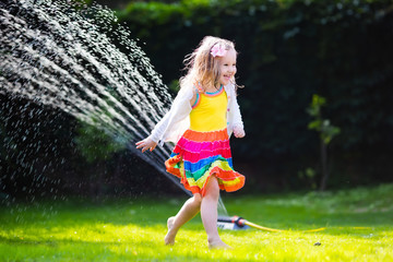 Kids playing with garden sprinkler