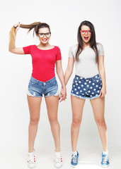 Two young girl friends standing together and having fun. 