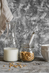 Homemade granola, milk bottle and ceramic bowl on a light background. Healthy food