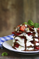 Chocolate pancakes with ricotta and strawberry.