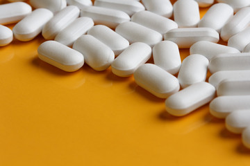 white pills on a yellow background