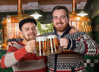 Young handsome bearded hipsters taste fresh beer in the brewery. Beer commercial.
