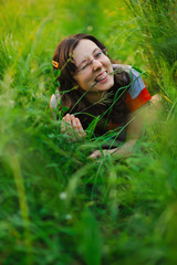 happy woman lying in green grass