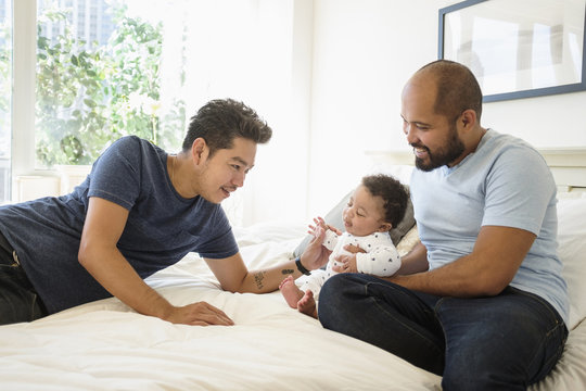 Couple playing with son on bed at home