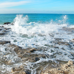 Big wave crashing on the rocks