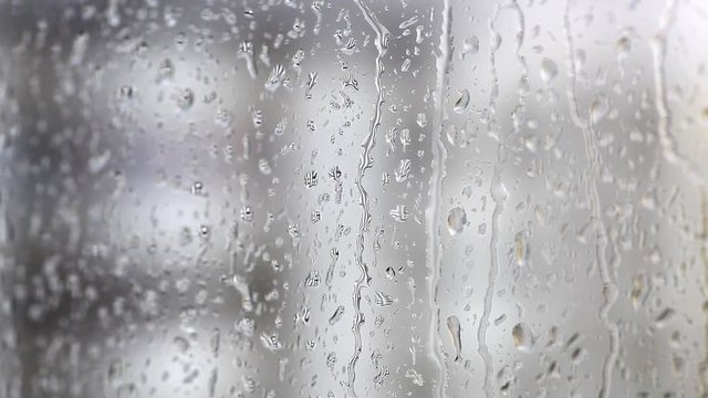 Color footage of some raindrops on a window, with selective focus.