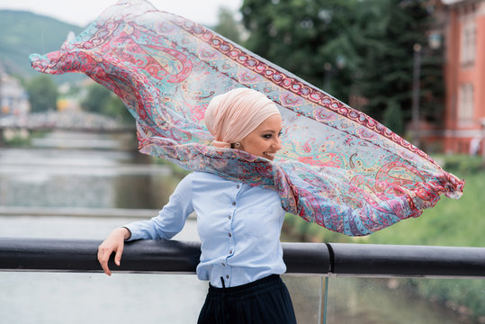 girl with hijab and scarf in air 