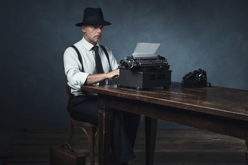 Vintage 1940 office worker behind desk with typewriter and telep