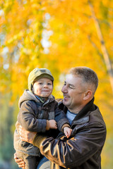 Father playing with his son in the park in autumn.