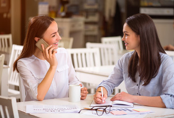 Positive  smiling friends sitting in the cafe