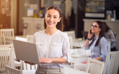 Pleasant  smiling woman holding laptop 