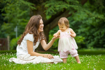 Mother and little daughter playing in the park