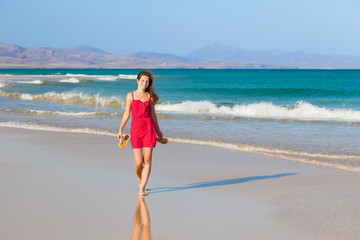 Fototapeta na wymiar Attractive young woman walking on the beach