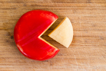 Wheel of fresh gouda cheese with a red rind