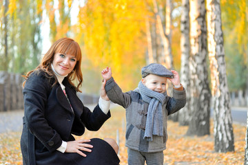Mother with baby in the park in autumn.