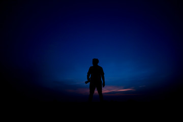 silhouette of man by holding camera at sunrise