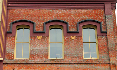 Fototapeta na wymiar Three Windows in a Red Brick Wall