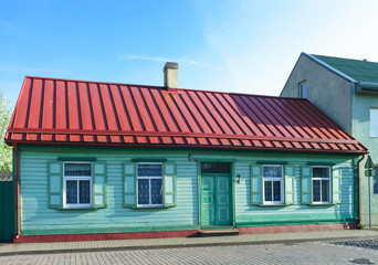 Old house painted green with red roof in Ventspils