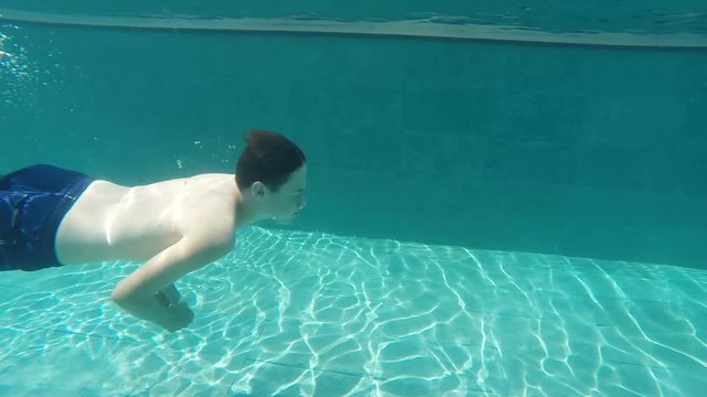 Teenager swim in swimming pool, slow motion
