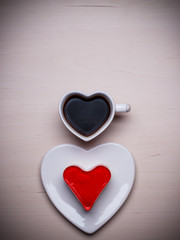 Heart shaped coffee cup and cake on wood surface