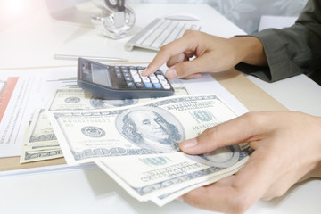Fototapeta premium business woman hold money dollar with calculator on tablet as fi