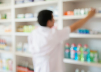 blur pharmacist taking medicine from shelf in the pharmacy