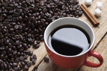 The red cup of coffee and coffee beans.