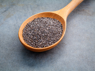 Nutritious chia seeds in wooden spoon for diet food ingredients.