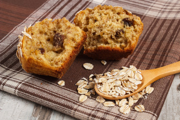 Fresh muffin with oatmeal baked with wholemeal flour on checkered tablecloth, delicious healthy dessert