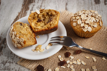Fresh muffins with oatmeal baked with wholemeal flour on white plate, delicious healthy dessert