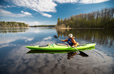 Kayaker on the lake, paddling, active lifestyle - obrazy, fototapety, plakaty