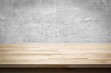 Wood table top on bare concrete wall background