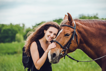 Fototapeta premium Uśmiechnięta dziewczyna przytula swojego konia