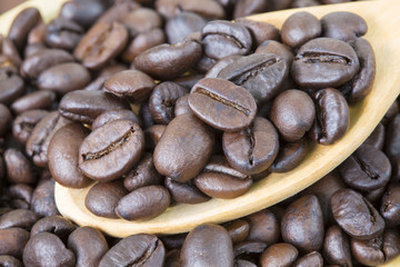 Coffee bean on wooden spoon background.