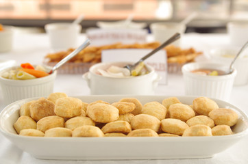 Small freshly baked bread muffins stacked in white glass tray, elegant food concept