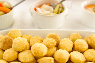 Small freshly baked bread muffins stacked in white glass tray, elegant food concept