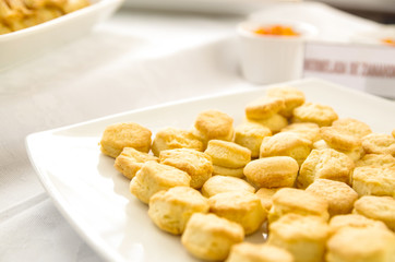 Small freshly baked bread muffins stacked in white glass tray, elegant food concept