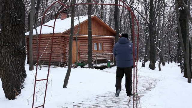 A man carrying the wood stove to a out-of-town house in the winter