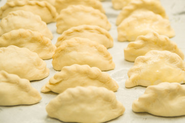 Closeup small delicious empanadas lined up before baking