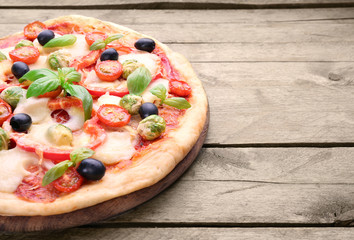 Delicious pizza with cheese and vegetables on wooden background