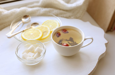 Tea set on a white wooden tray on the windowsill