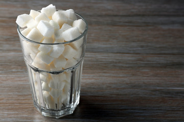 Highball glass with lump sugar on wooden table
